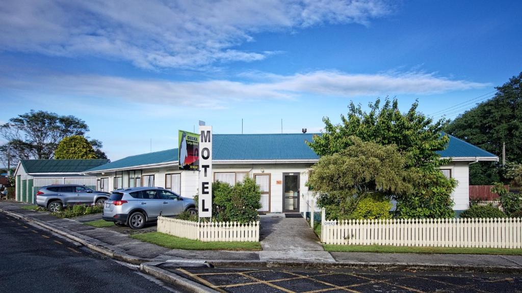 un edificio blanco con coches estacionados frente a él en Owaka Lodge Motel, en Owaka