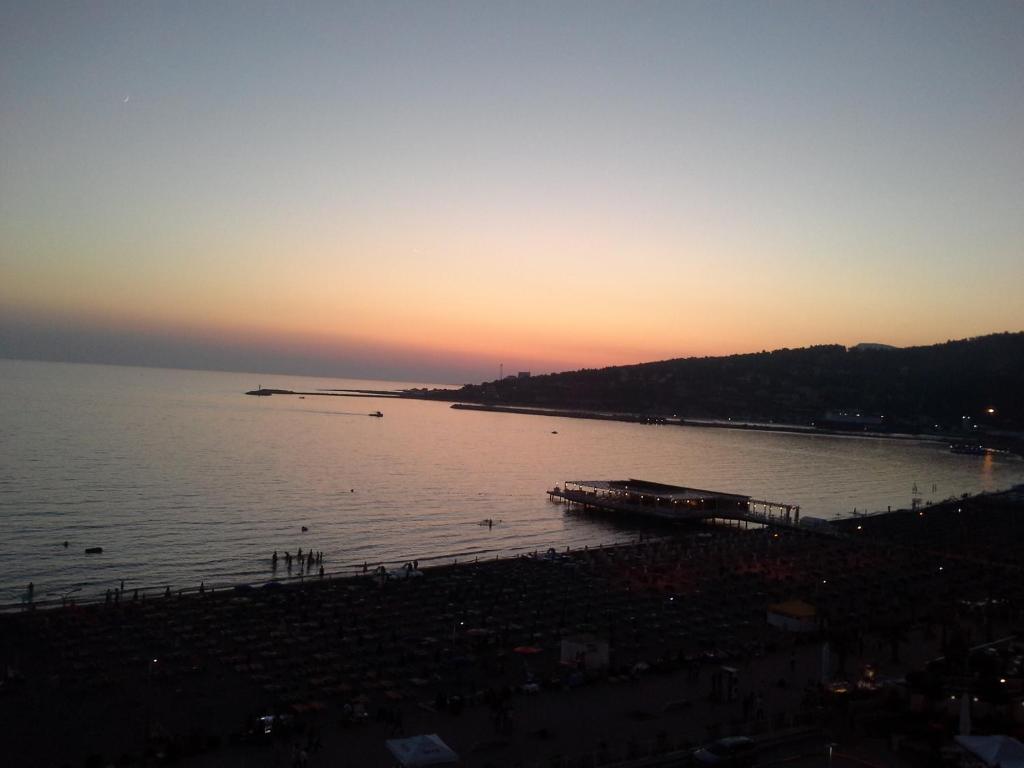a sunset over a body of water with a pier at Nada SeaView Apartment in Shëngjin
