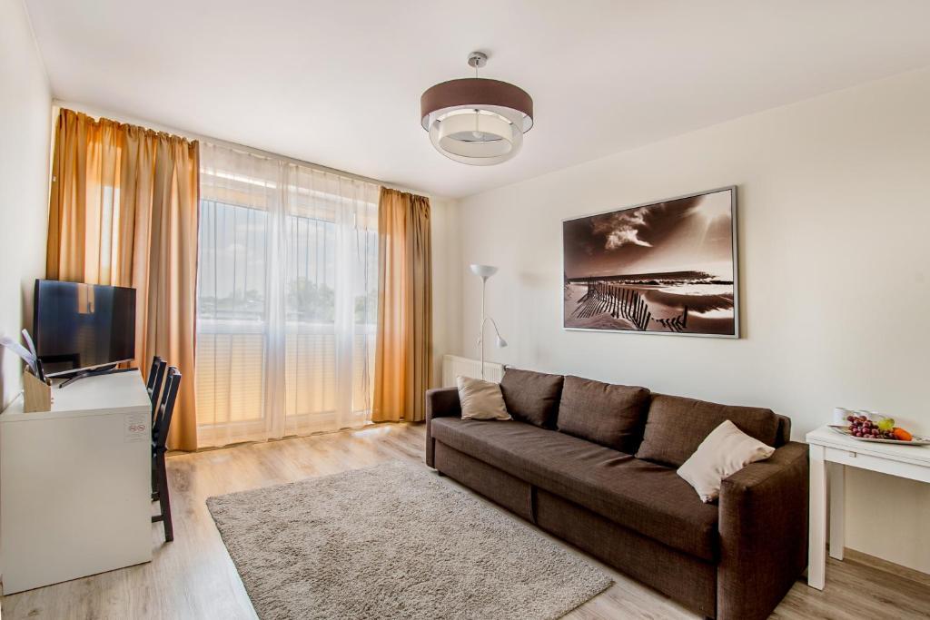 a living room with a couch and a tv at Apartament Poniatowskiego - Komfortowe Noclegi in Piaseczno