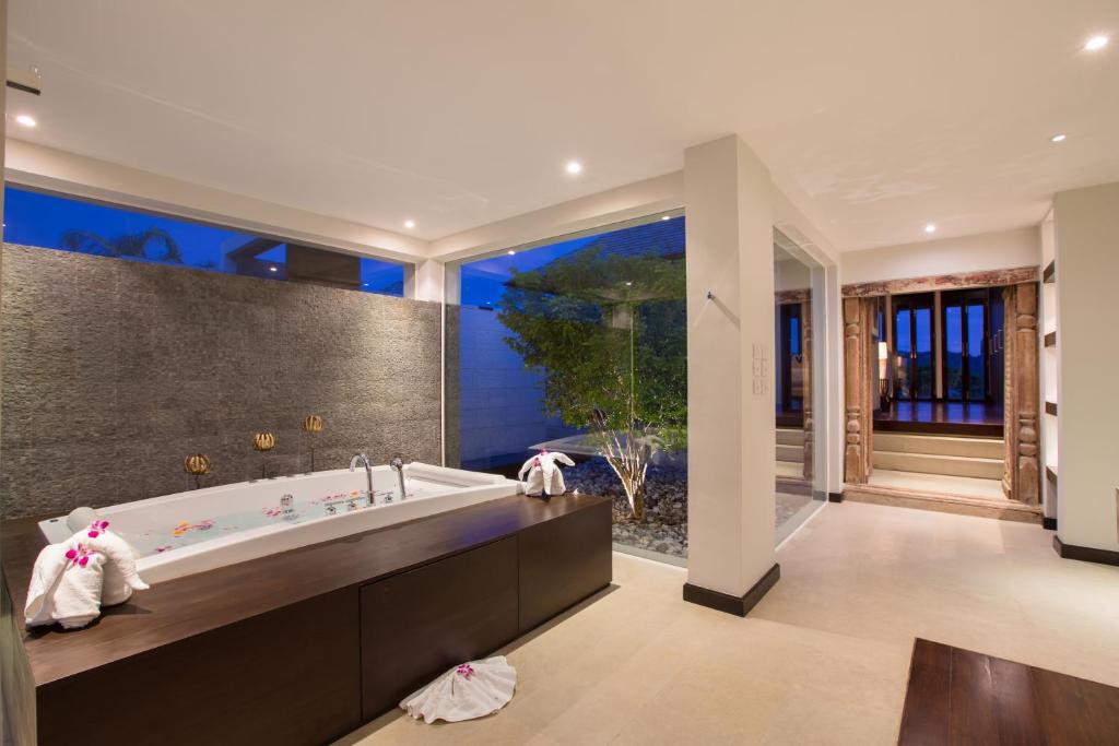 a bathroom with a tub and a large window at Villa Princess Stephanie in Kata Beach