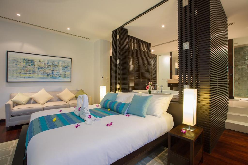 a bedroom with a large white bed and a couch at Villa Princess Stephanie in Kata Beach
