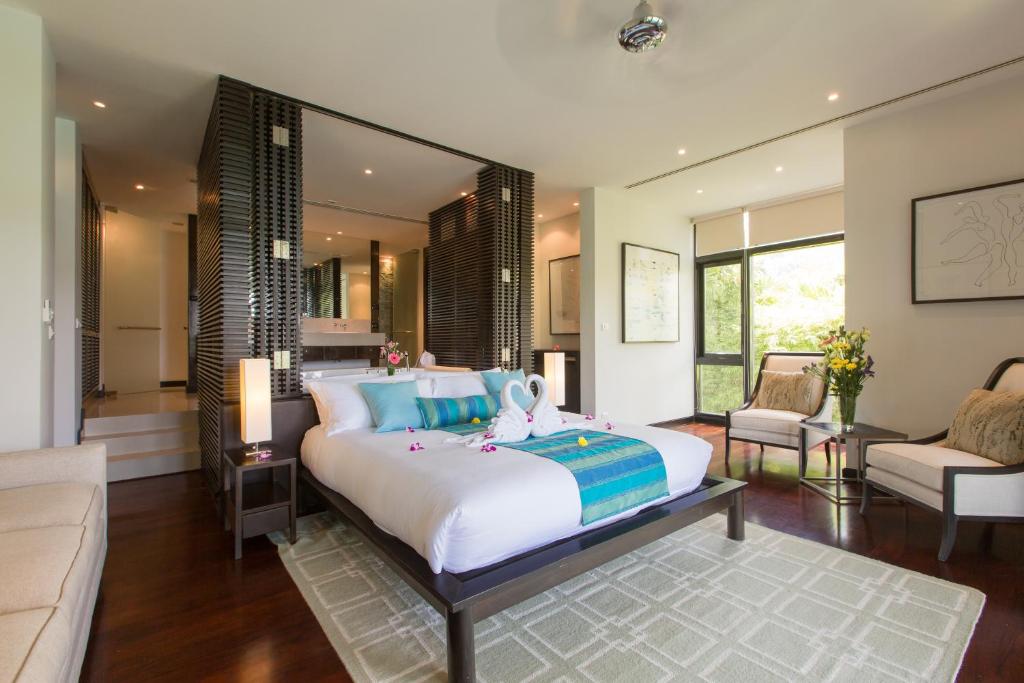 a bedroom with a large bed and a living room at Villa Princess Stephanie in Kata Beach
