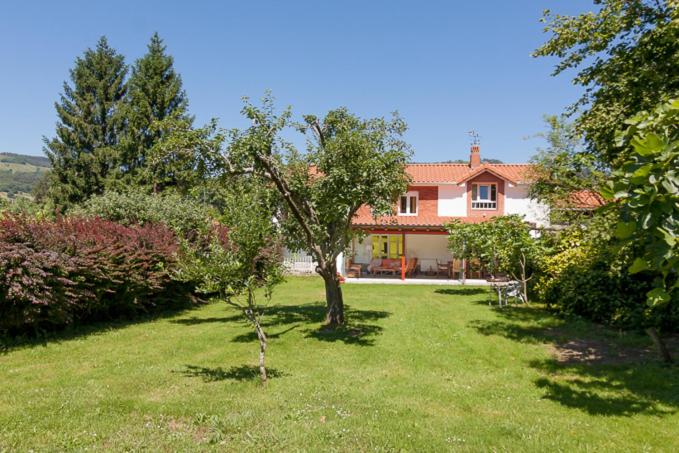 a house with a green yard with a tree at La Torrentera de Cantabria in Rada