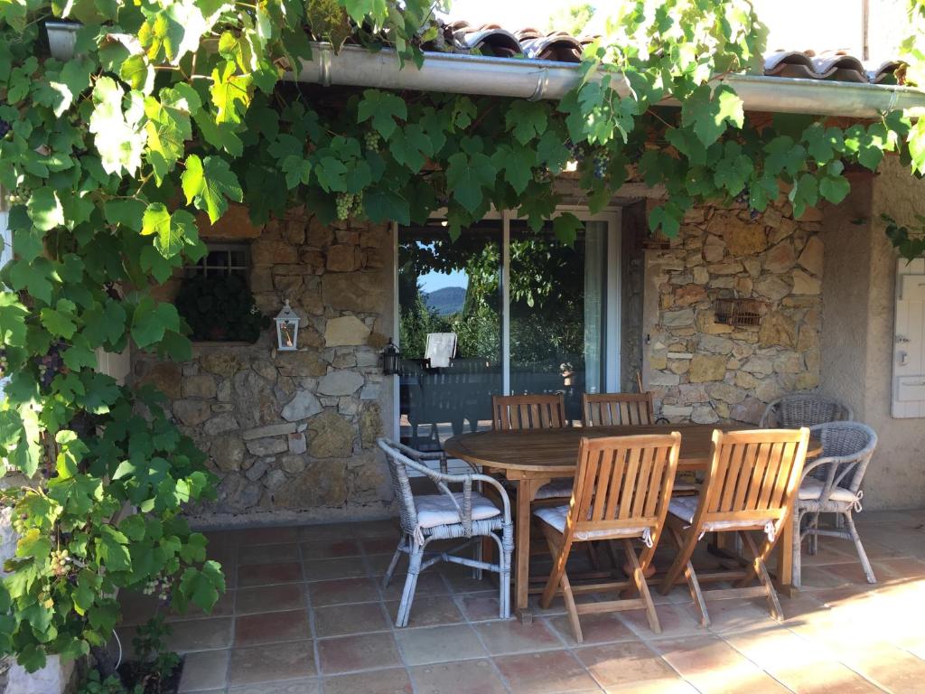 une table et des chaises en bois sur une terrasse dans l'établissement Maset des Amandiers, à Cotignac