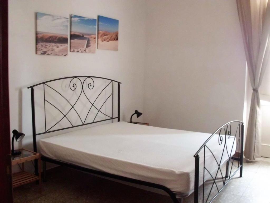 a bedroom with a bed with a metal bed frame at Appartamenti Dalì in Bernalda