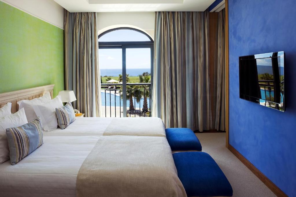 a hotel room with a large bed and a large window at Cascade Wellness Resort in Lagos