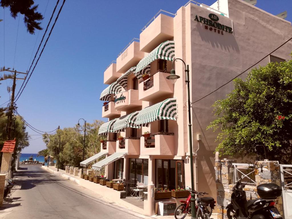 a large pink building on the side of a street at Aphrodite Boutique Hotel in Kinion