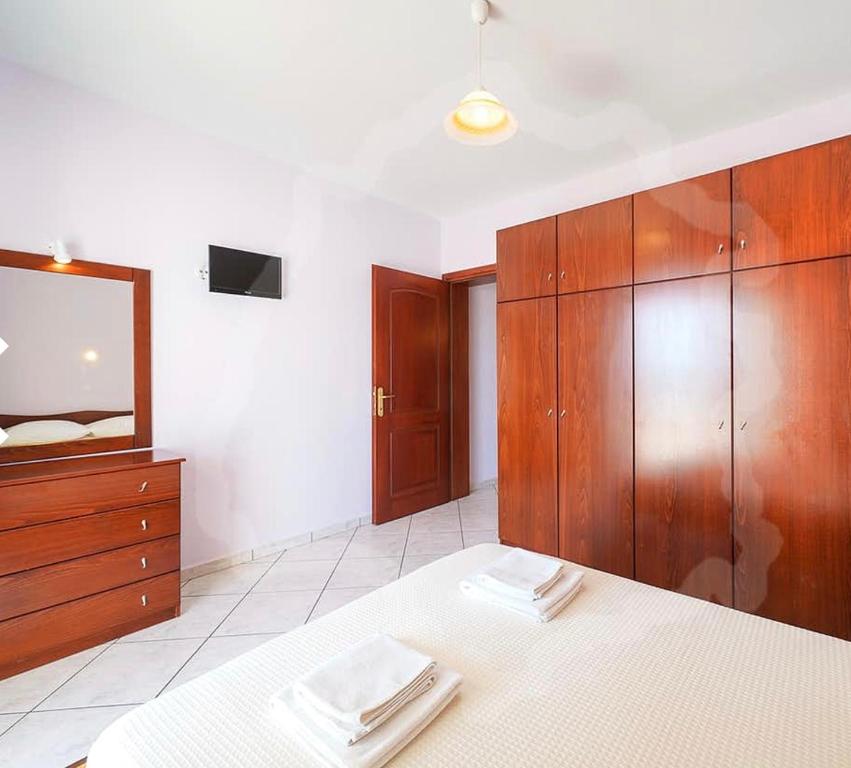 スカラ・ポタミアスにあるMakioulas apartmentsのベッドルーム1室(ベッド1台、ドレッサー、鏡付)