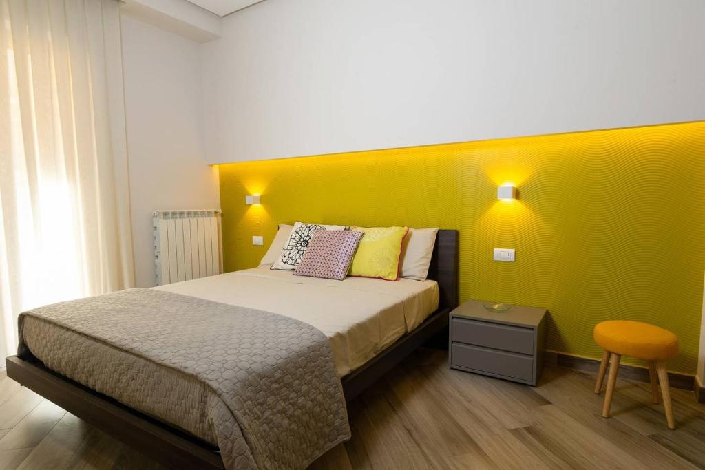 - une chambre dotée d'un lit avec un mur jaune dans l'établissement Casa Martina, à Castellammare di Stabia
