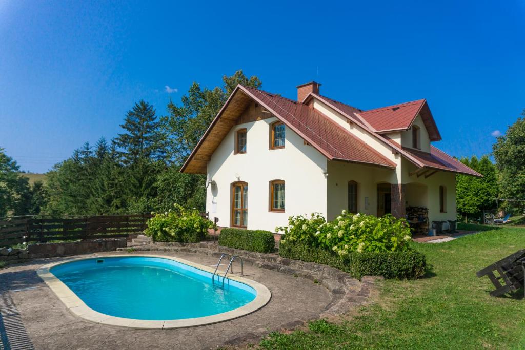 una casa con piscina frente a ella en Holiday Villa Javornik en Javorník