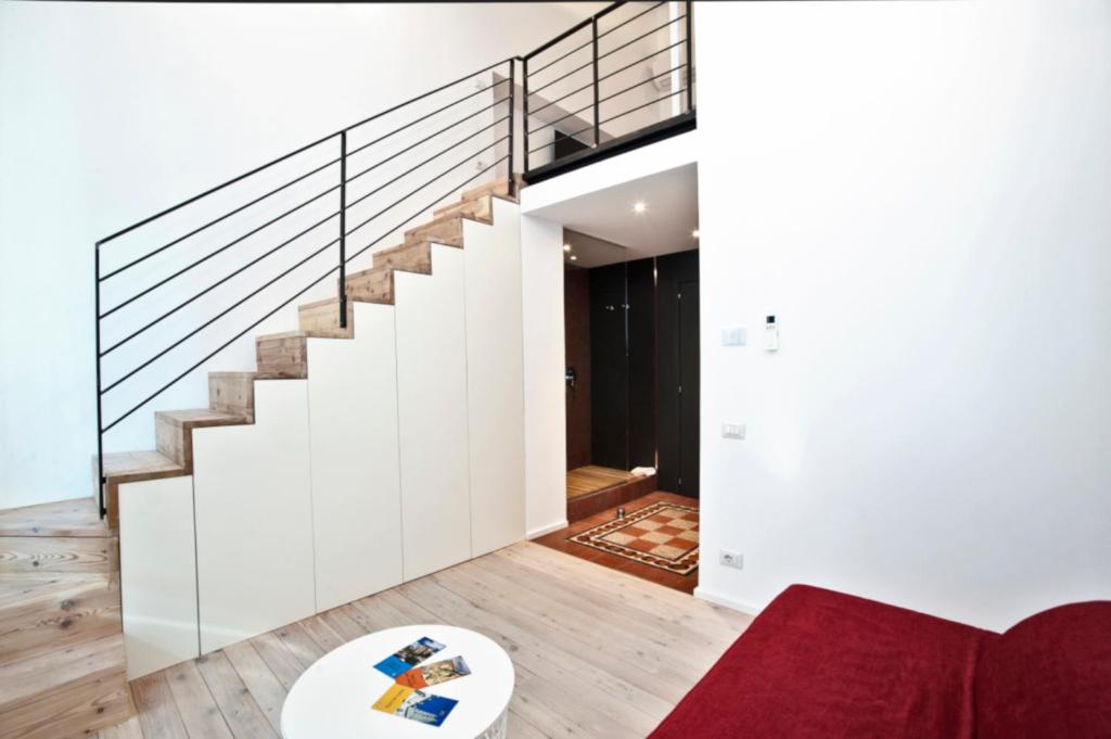 een woonkamer met een trap en een rode bank bij La Barriera di San Lorenzo - Dimora Storica in Siena