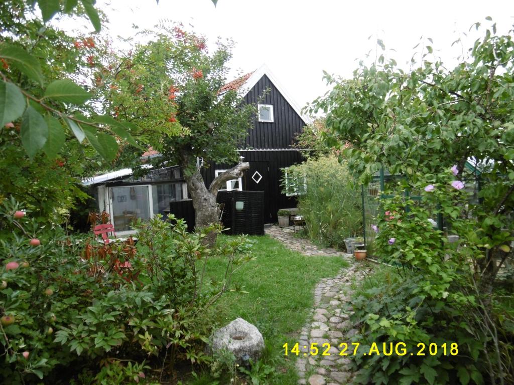 un jardín con una casa negra en el fondo en 4 Louisenlund en Skanderborg
