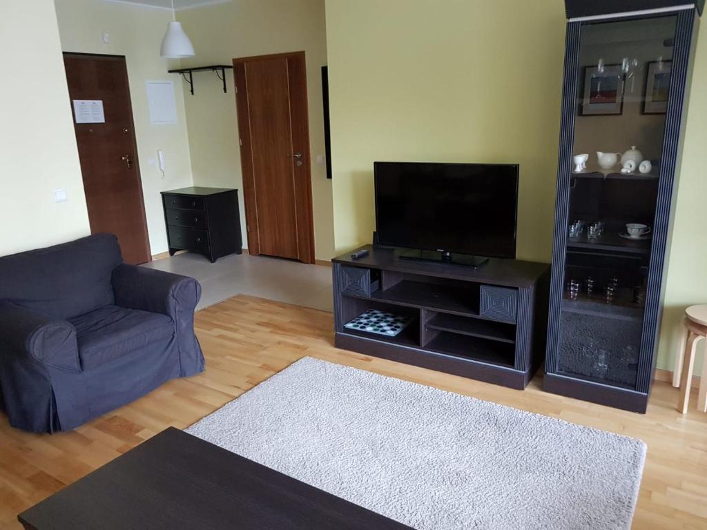 a living room with a couch and a flat screen tv at Aquamarina Międzyzdroje in Międzyzdroje