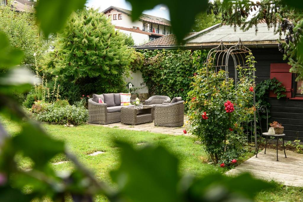um jardim com sofás e um gazebo em Gästehaus Schmid em Oberstaufen