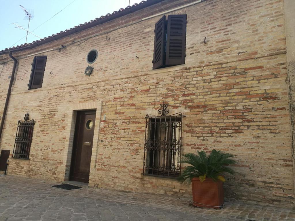 un edificio de ladrillo con una planta delante en Casa vacanze Le mura, en Fano