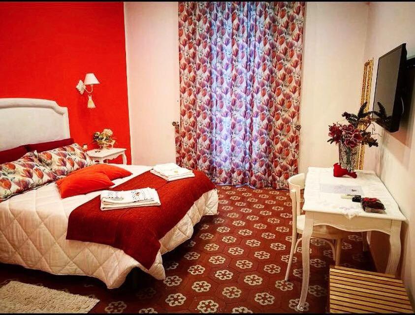 a bedroom with a bed and a desk and a television at B&B Resta Cu Mme in Naples