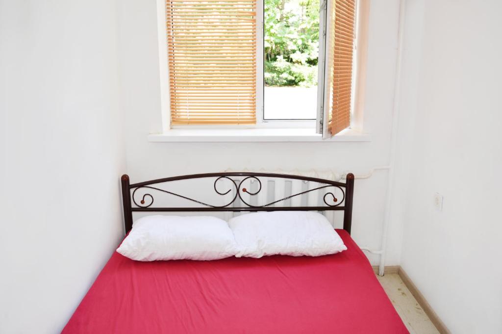 a bedroom with a red bed with a window at Hostel Railway Kiev in Kyiv