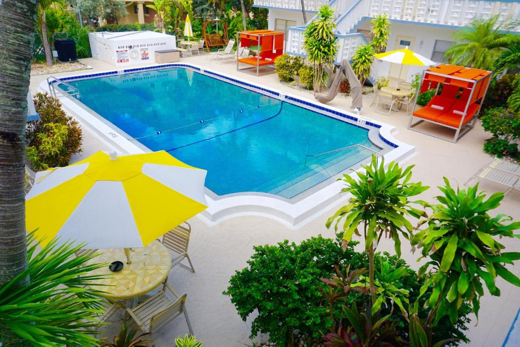 an overhead view of a swimming pool with an umbrella at Club Lux Resort By The Beach in Deerfield Beach