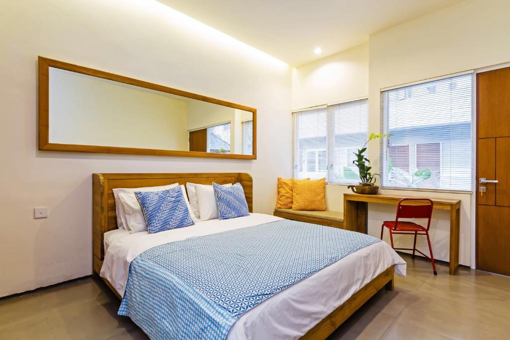 - une chambre avec un lit, un bureau et un miroir dans l'établissement Seruni Guest House, à Denpasar