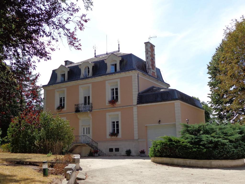 a large house with a chimney on top of it at La Maison Ribotteau in LʼIsle-Jourdain