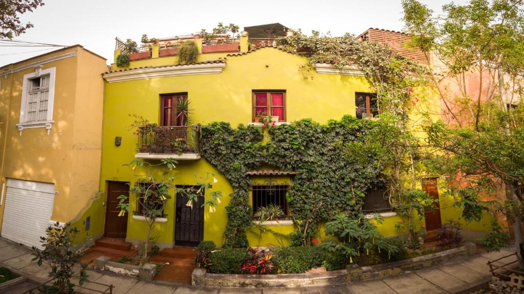 une maison jaune avec des plantes sur son côté dans l'établissement Casa Nuestra Peru, à Lima