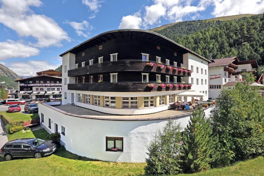 ein großes weißes Gebäude mit schwarzem Dach in der Unterkunft Berghotel-Gasthof Gstrein in Vent