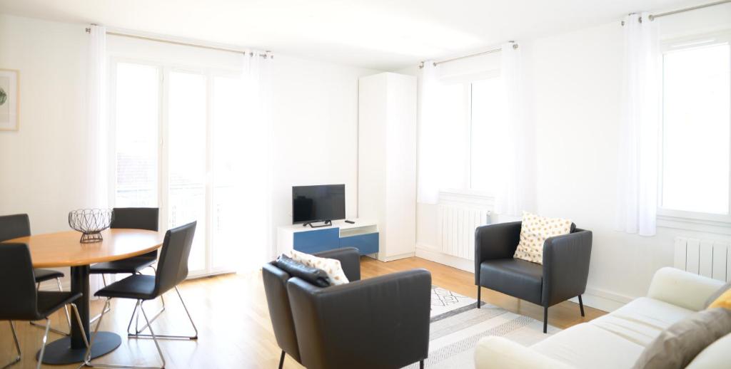 a living room with a couch and a table and chairs at Appart' Préférence in Lyon