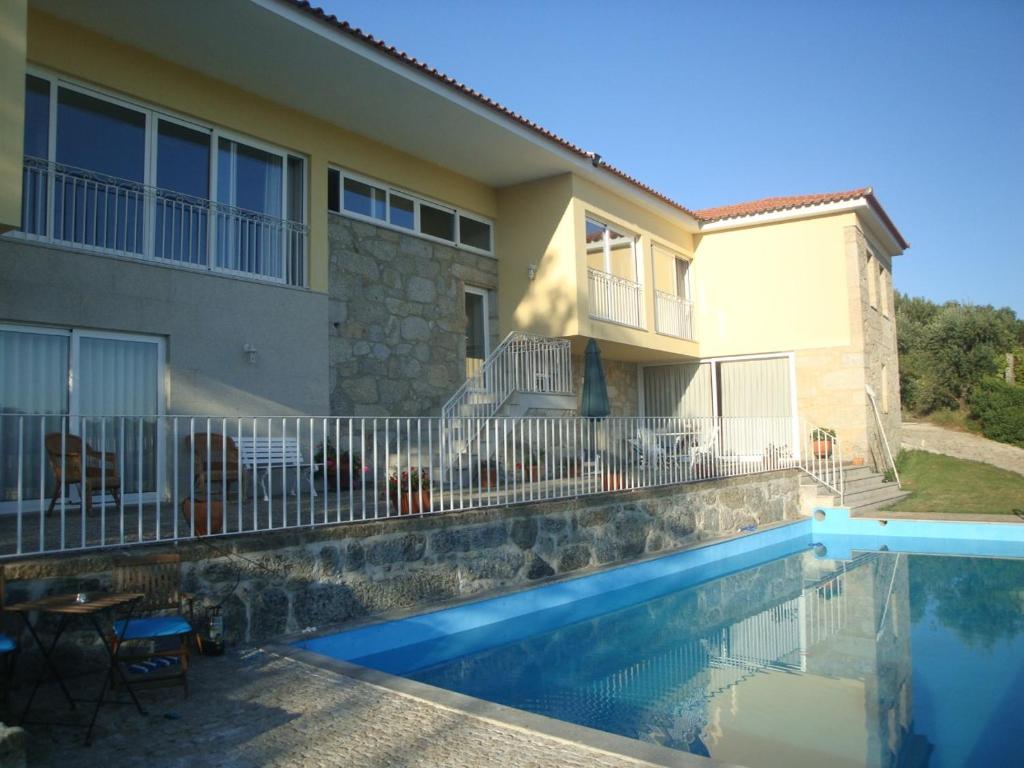 a house with a swimming pool in front of a house at Quinta do Toutuço in Arouca