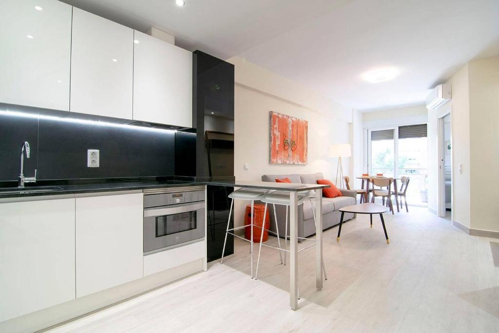 a kitchen with black and white cabinets and a table at Beautiful Apartment next to Santiago Bernabeu by Batuecas in Madrid