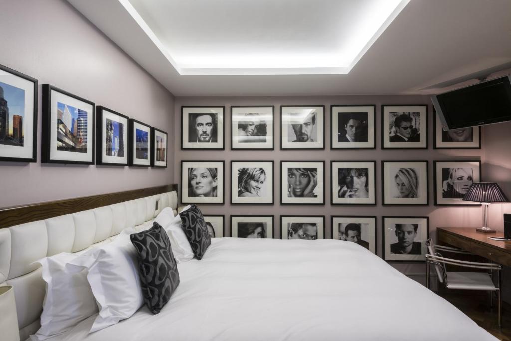 a bedroom with a white bed with pictures on the wall at Le Monde Hotel in Edinburgh