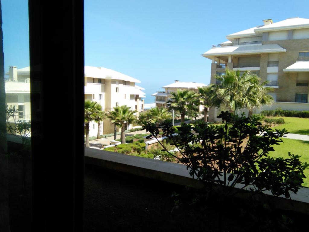 a view from a window of a building with palm trees at Prestigia PDN in Sidi Bouqnadel