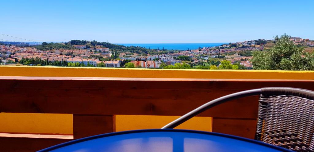 a chair on a balcony with a view of a city at Moinho16 - Lisbon Mills in Oeiras