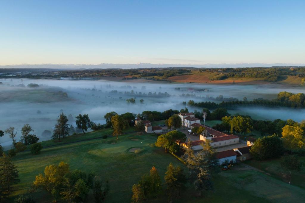 an aerial view of a house in the middle of a lake at Domaine de Pallanne in Tillac