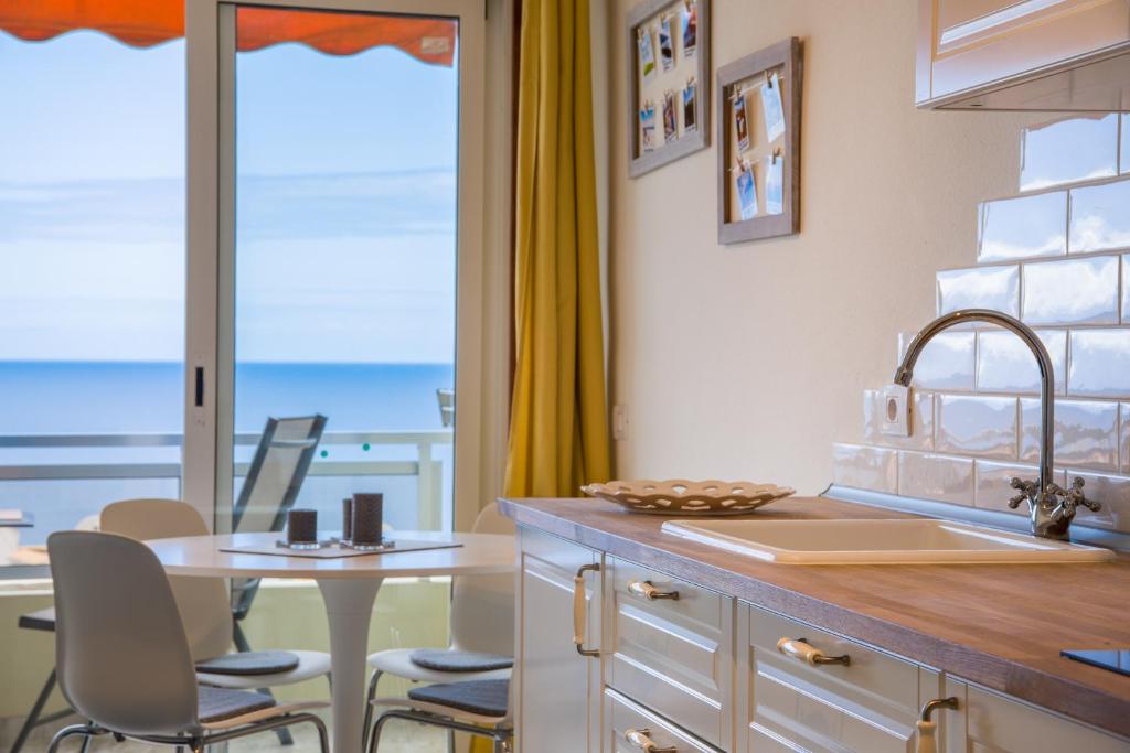 プエルト・デ・サンティアゴにあるAmazing view you fall in love withのキッチン(テーブル付)、景色を望むダイニングルームが備わります。