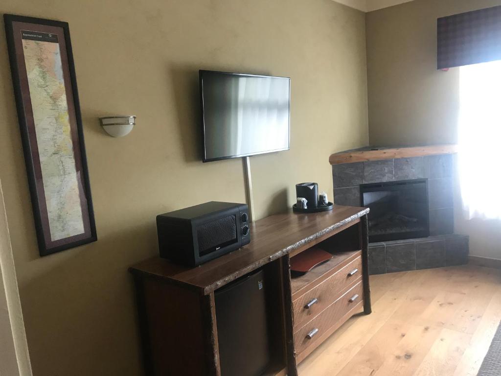 Zimmer mit einem TV auf einem Schreibtisch und einem Kamin in der Unterkunft The Appy Lodge in Gatlinburg