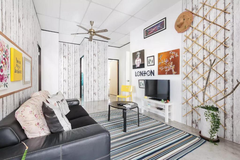 a living room with a couch and a tv at @ DE GARDEN ** AEON•IKEA•TESCO•THEMED• DESA TEBRAU JOHOR BAHRU in Johor Bahru
