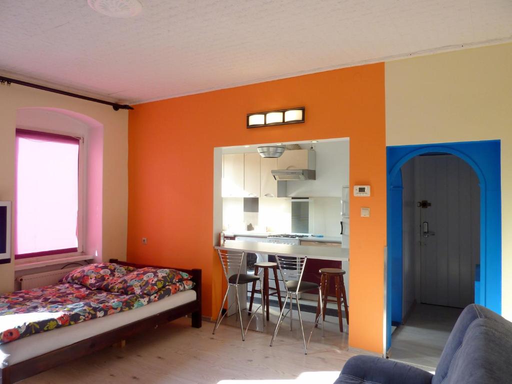 シュチェチンにあるMieszkanie Centrum Bon Turystycznyのオレンジ色の壁のベッドルーム(ベッド1台付)、