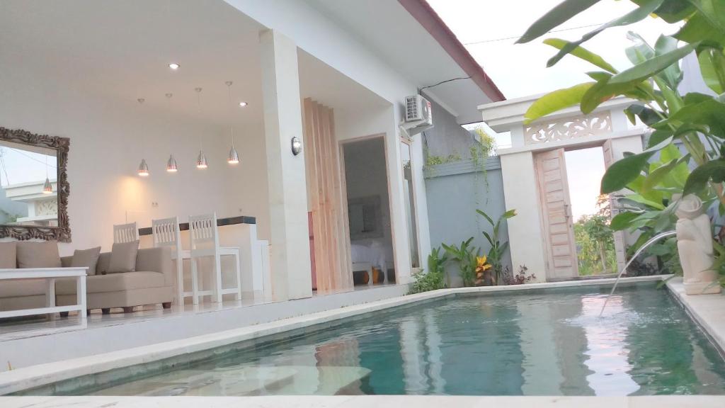 a villa with a swimming pool and a living room at Villa Ummangur 2 BR Private Villa Near Lovina in Banjar
