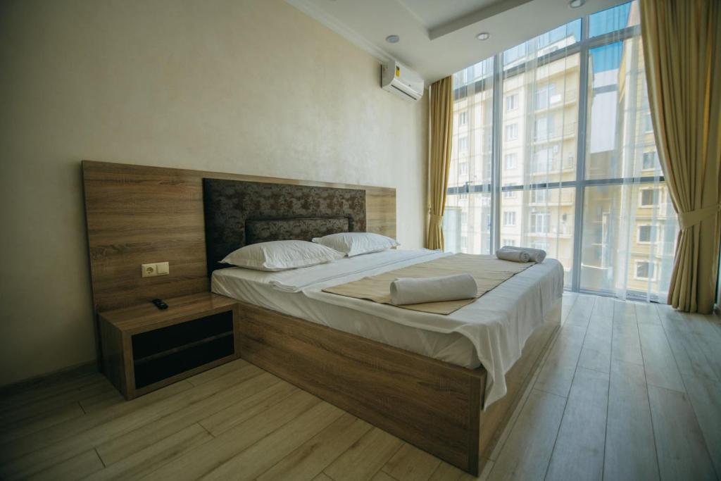 a bedroom with a large bed and a large window at Hotel Batumi Palace in Batumi