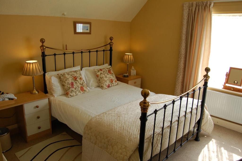 a bedroom with a large bed and a window at Compton House in Ashbourne