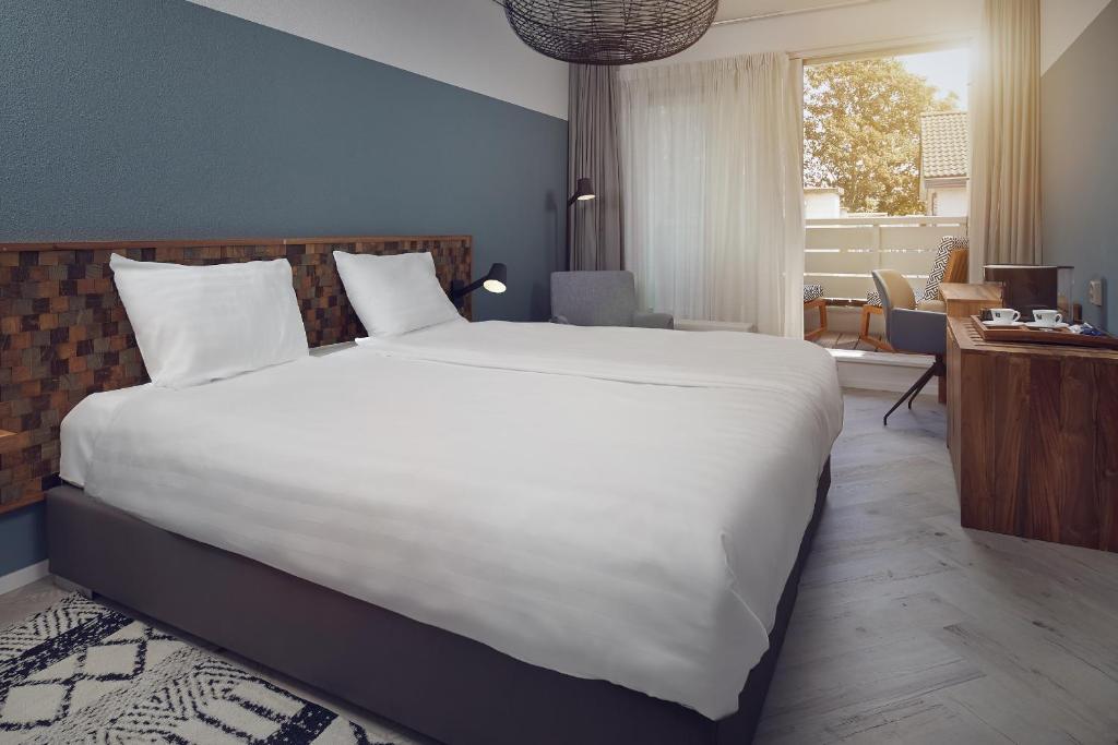 Postel nebo postele na pokoji v ubytování Romantik Badhotel Renesse