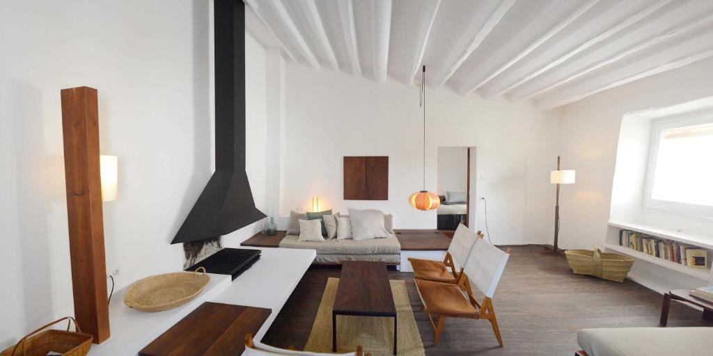 a living room with a fireplace and a bed at Cozy Townhouse in the heart of Cadaqués by by JA Coderch in Cadaqués