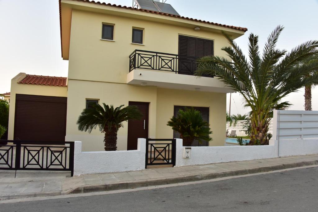una casa con palmeras delante en Limni Pool House, en Oroklini