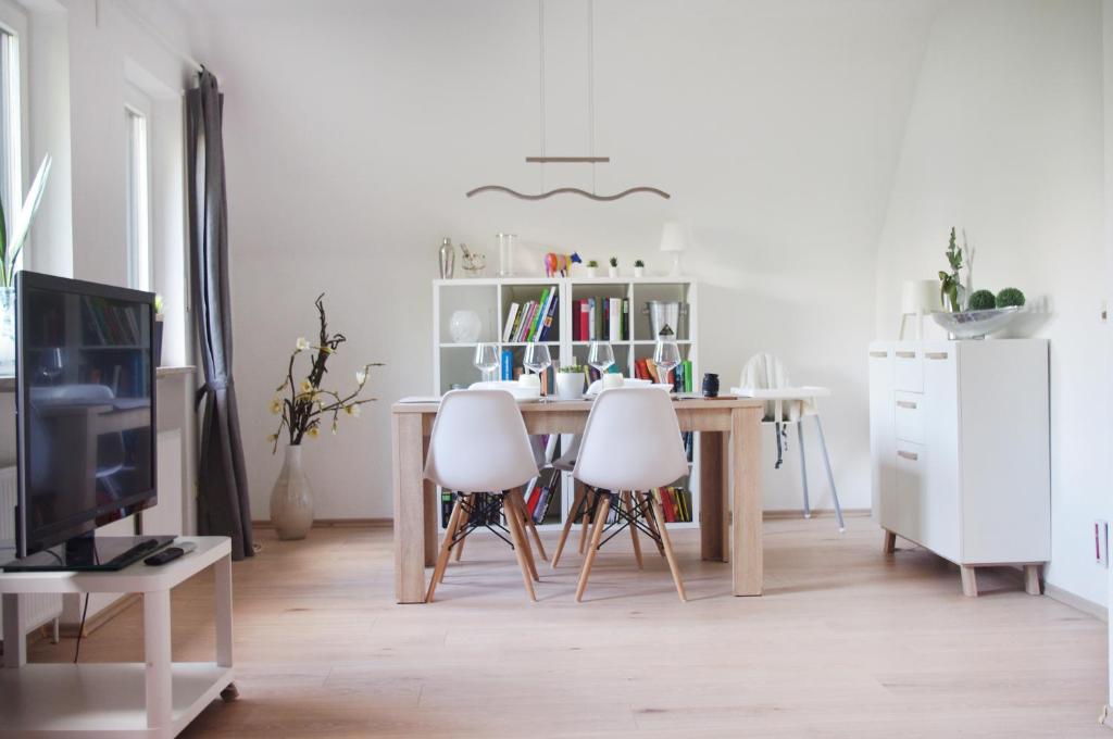ein Wohnzimmer mit einem Tisch und 2 weißen Stühlen in der Unterkunft Ferienwohnung Alte Lahnbrücke in Limburg an der Lahn
