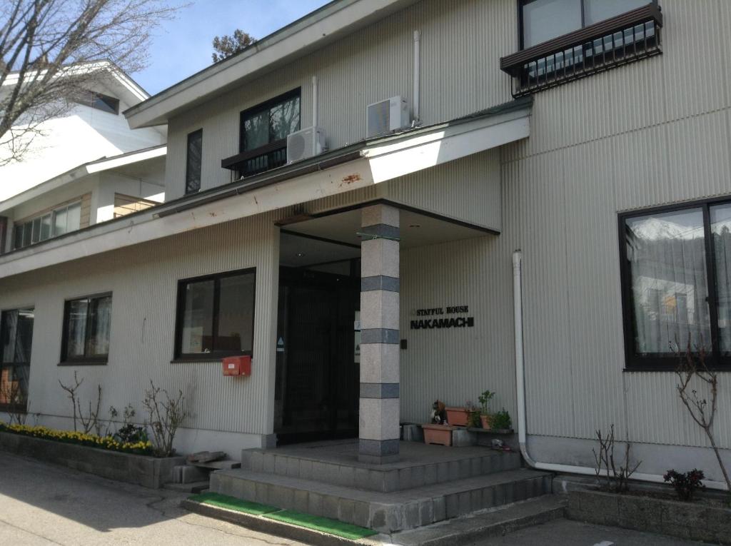 un edificio con la entrada delantera de un edificio en Stayful House Nakamachi, en Hakuba