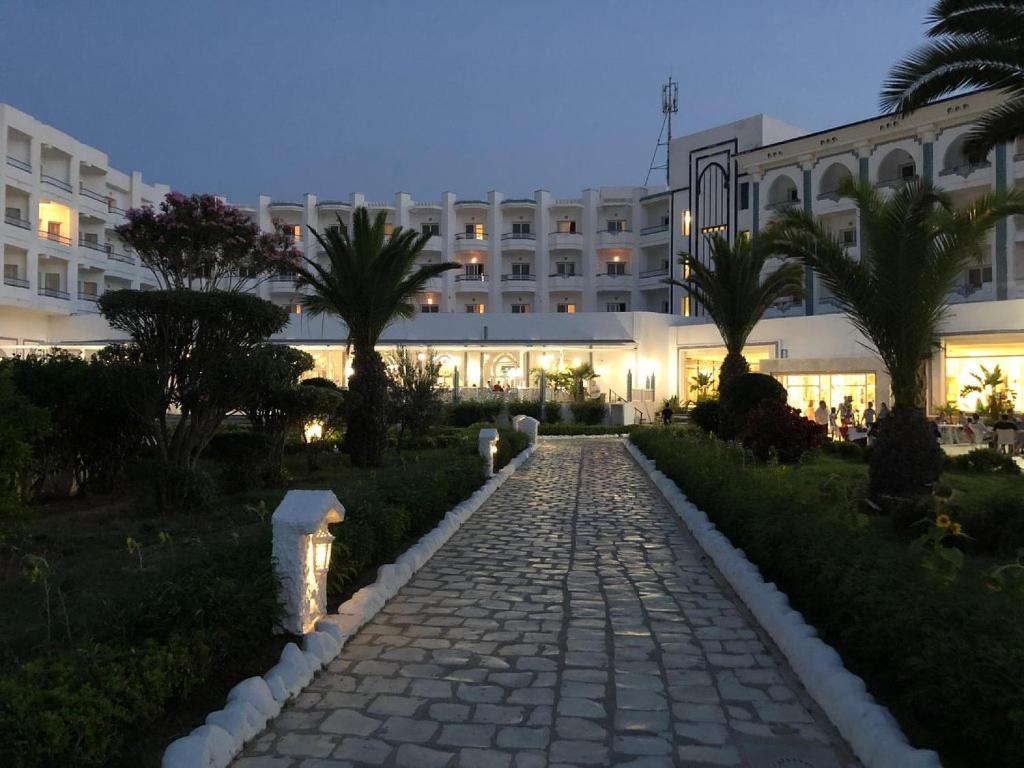 un chemin pavé devant un grand bâtiment dans l'établissement Chiraz Club - Families Only, à Monastir