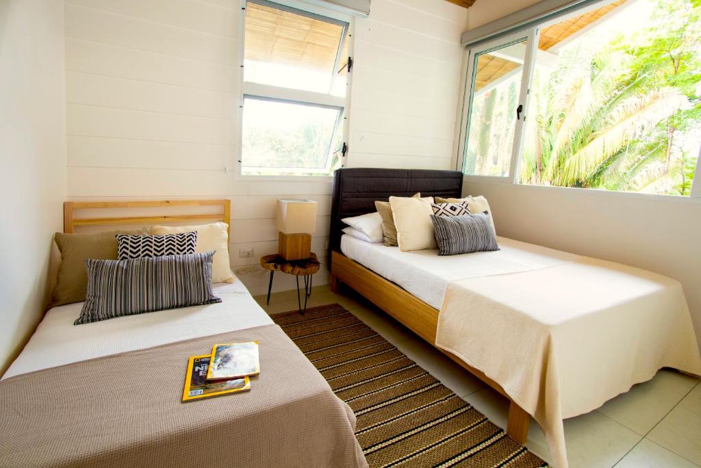 2 łóżka w małym pokoju z oknem w obiekcie marAmar Bungalows by STH w mieście Playa Santa Teresa