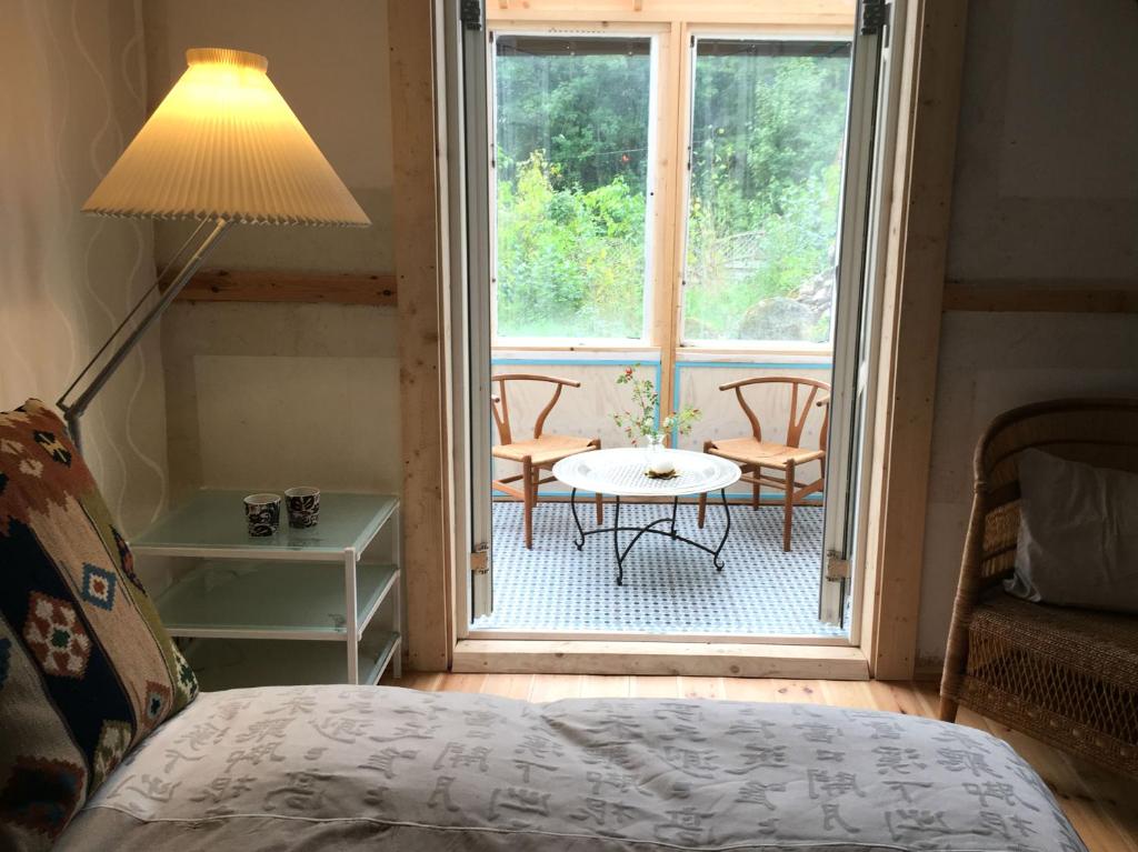 a bedroom with a bed and a table and a window at Lille Carlsson Studio in Broby