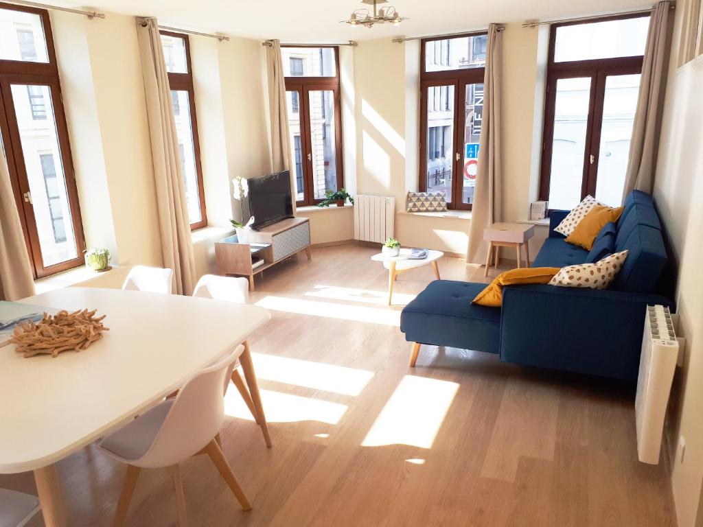 a living room with a blue couch and a table at Appartement 60m2 / Hyper Centre (Gares et Vieux Lille) in Lille