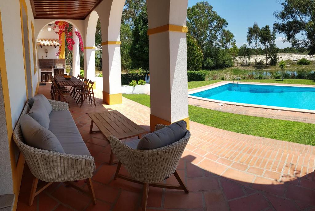 a patio with chairs and a swimming pool at Villa Sequoia - Beach and Lake Private Holidays in Troia